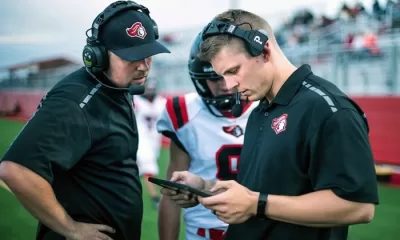 A coach holding a smartphone