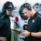 A coach holding a smartphone